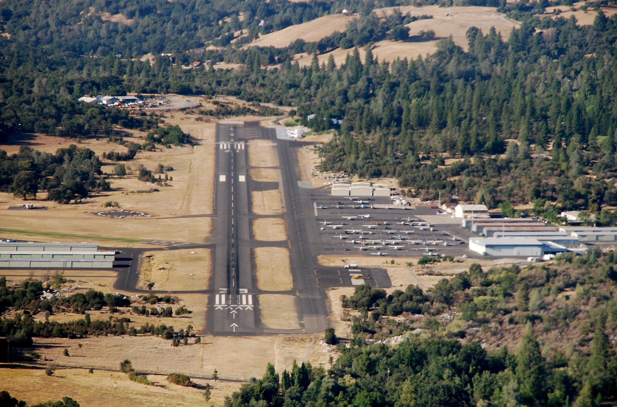 Aerial view of Columbia Airport: the paved runway, parallel grass strip, hangars and parked light aircraft