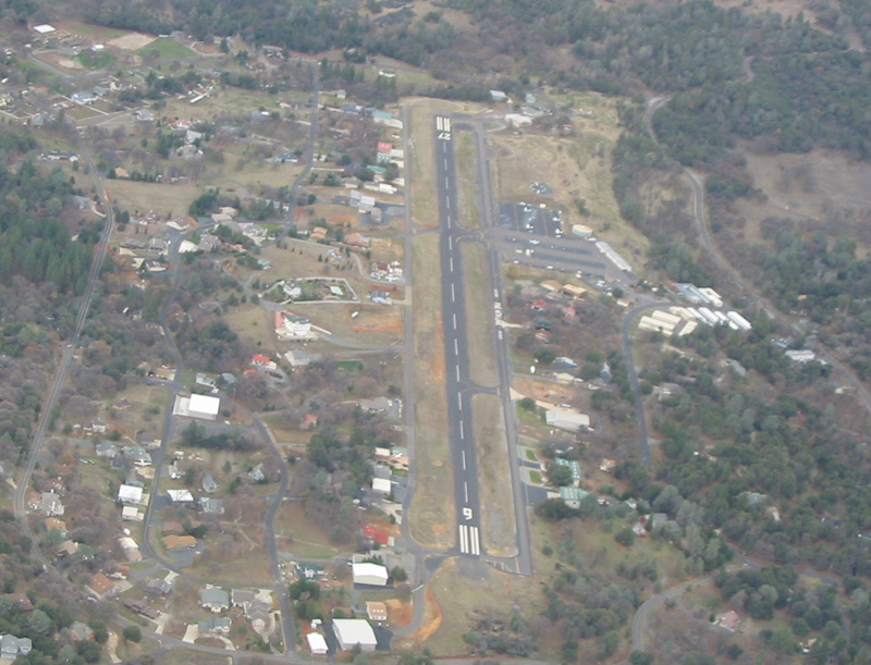 Aerial view of the Groveland-Yosemite Airport runway with hangars and Pine Mountain Lake homes around it