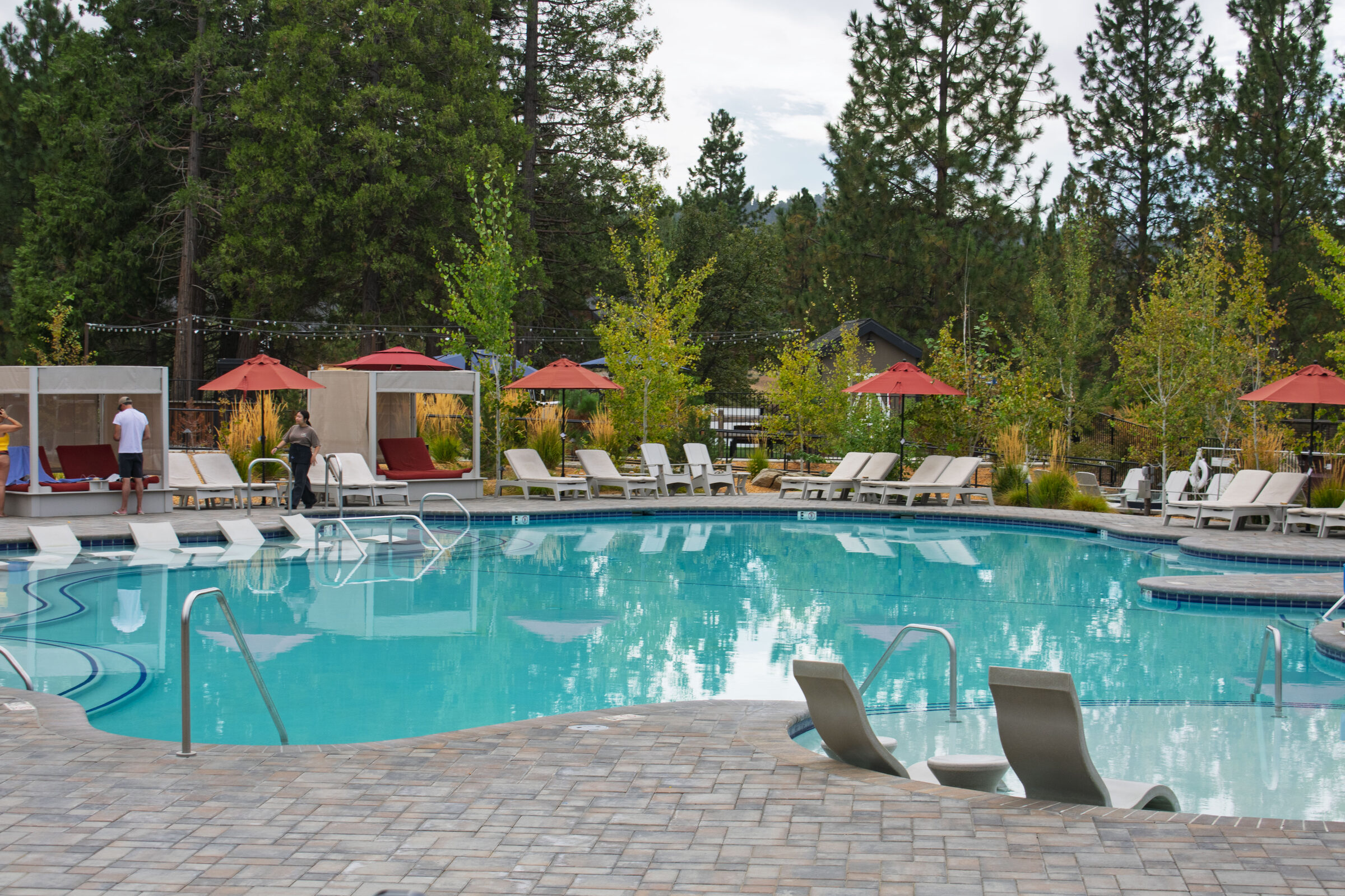 The pool with cabanas and red umbrellas at Firefall Ranch near Groveland