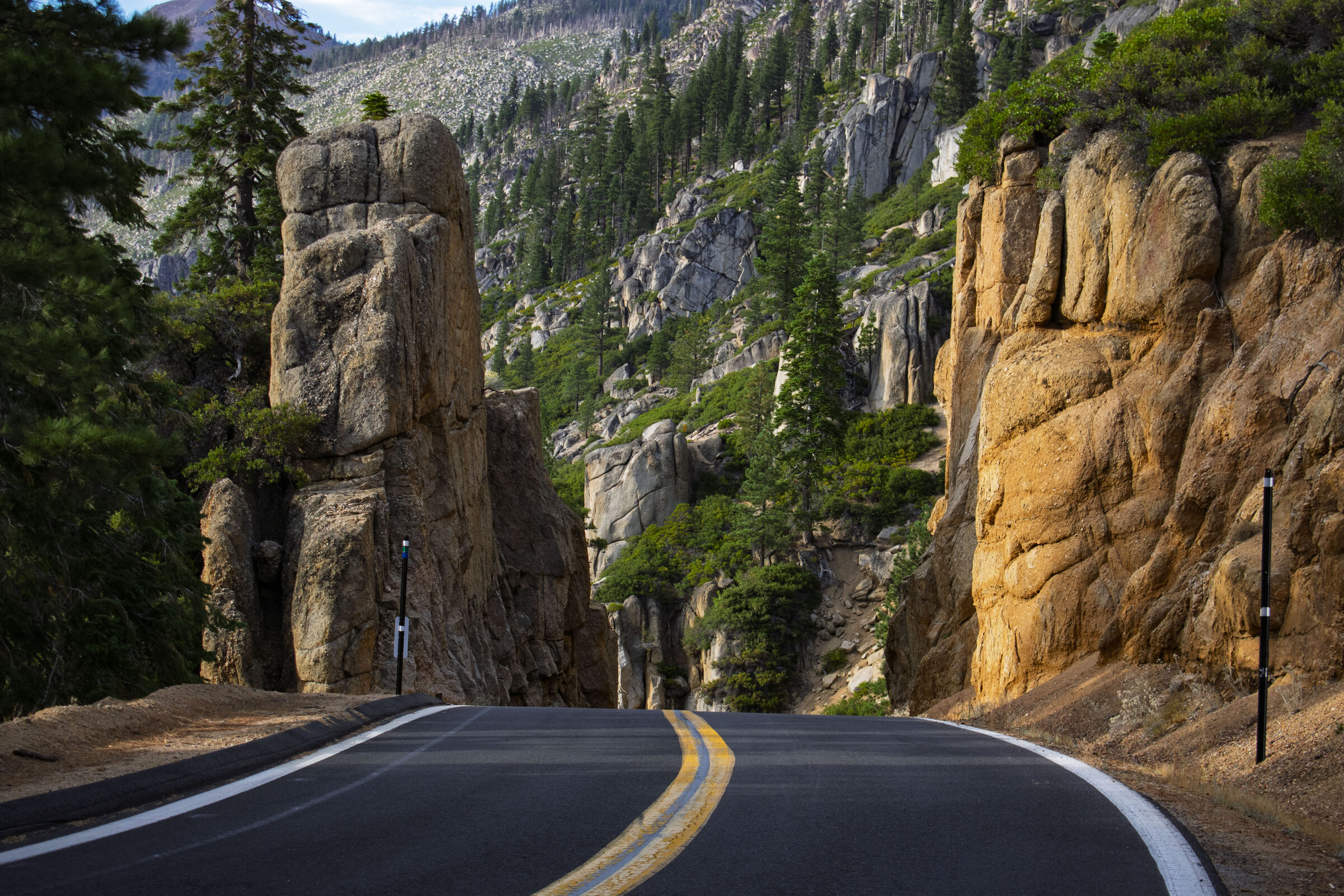 Highway 108 curving between tall granite spires and pines in the Stanislaus National Forest