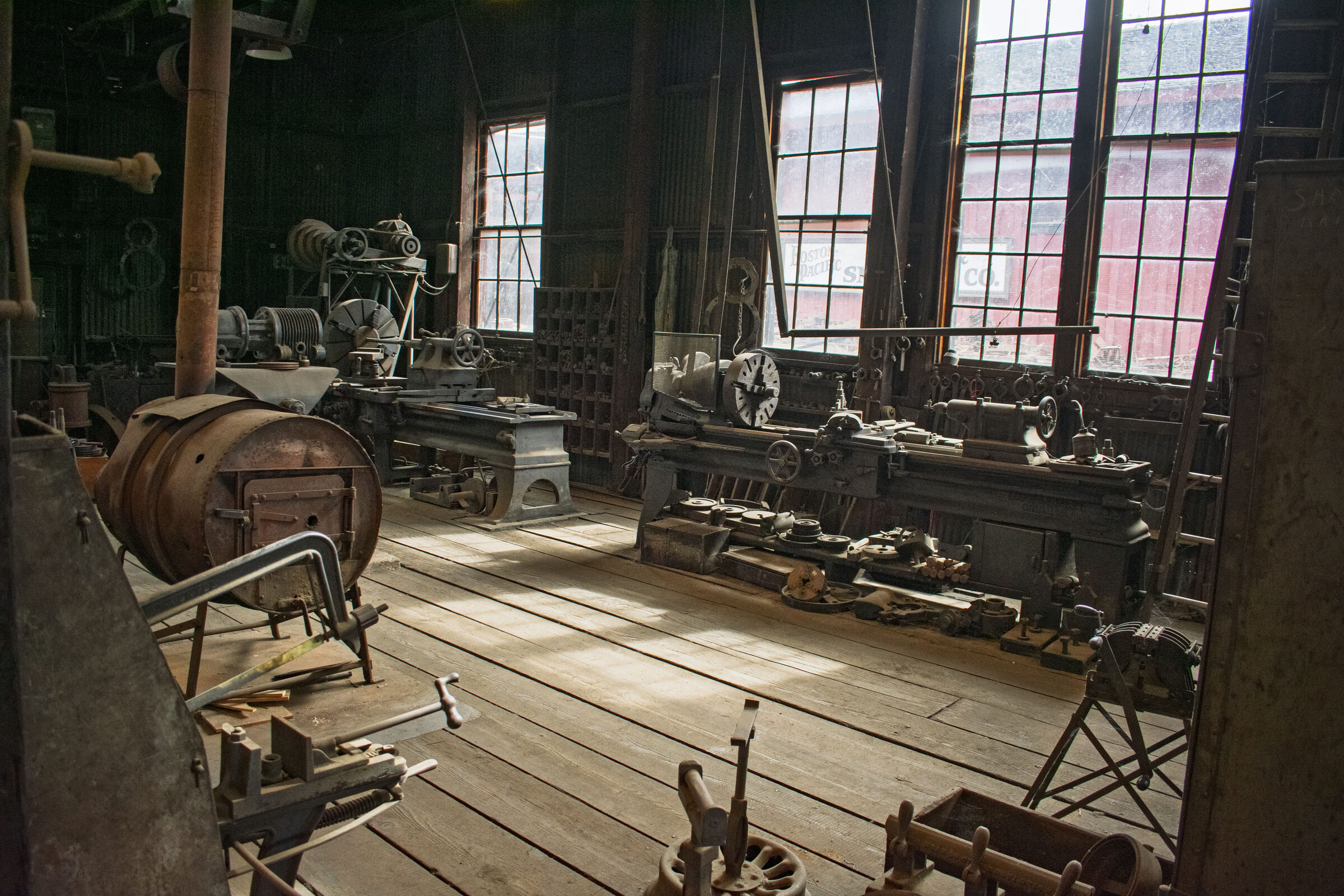 Lathes, belts and tools on the wooden floor of the Railtown 1897 machine shop