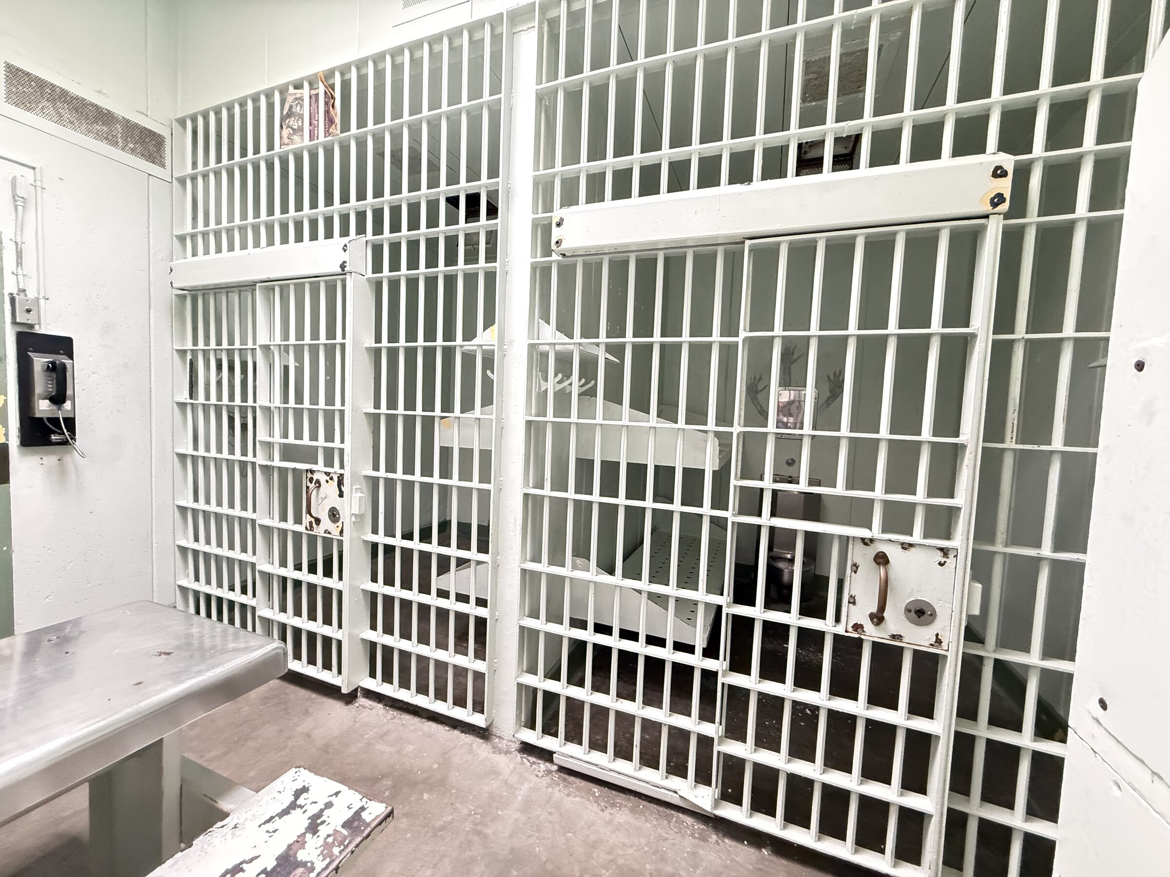 A row of barred cells with open doors inside the vacant Tuolumne County Jail